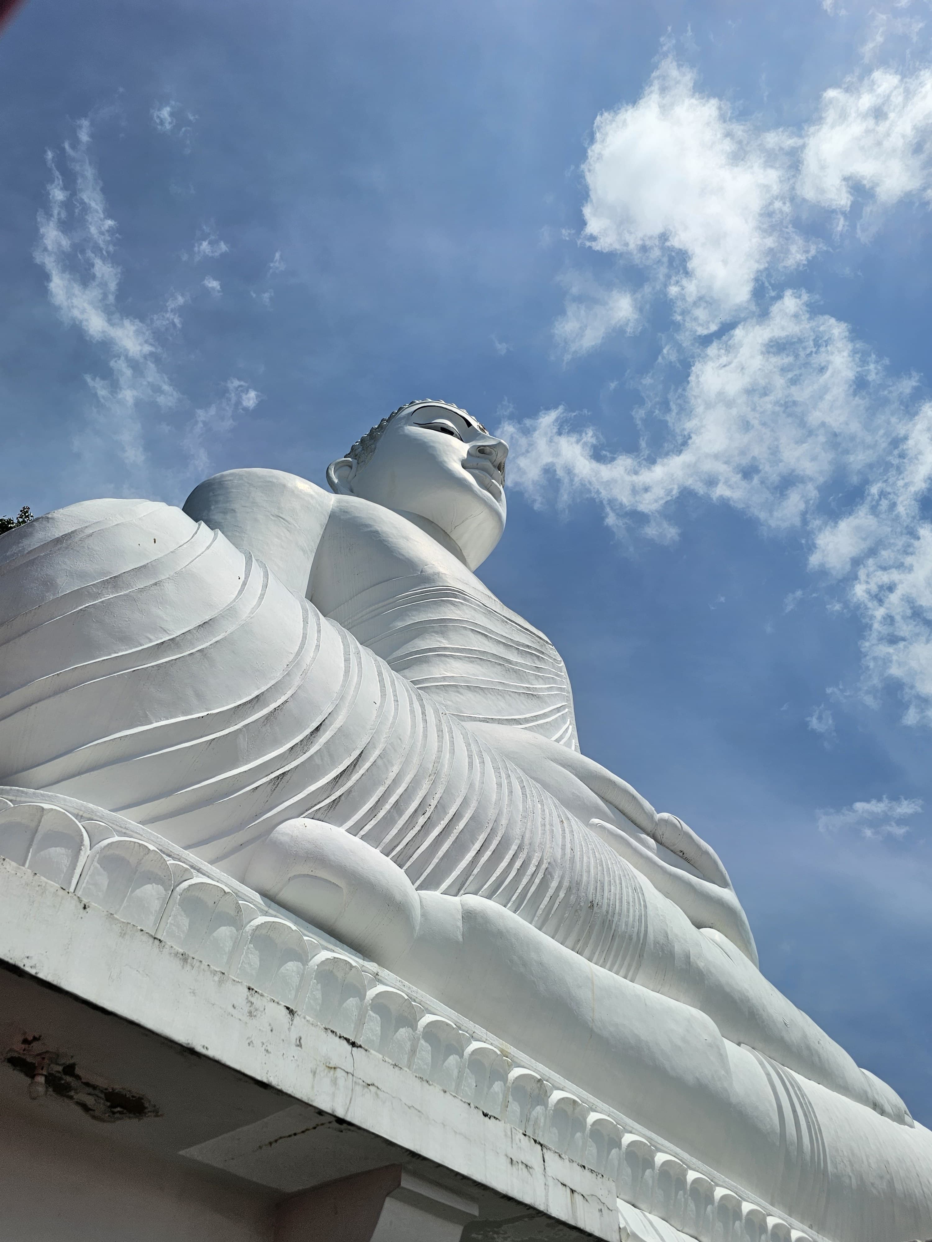 Statue monumentale de Bouddha humant paisiblement les nuages
